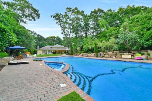 a swimming pool in a backyard with a brick walkway around it at Amazing Pool Private Oasis! 25 Mins 2 Westhampton! in Wading River