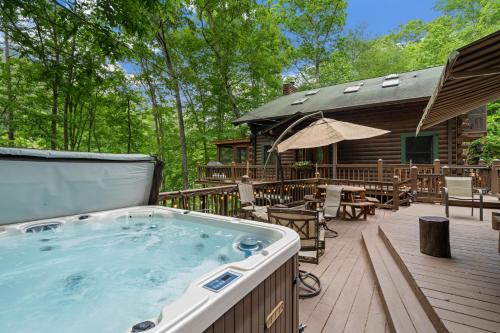 a hot tub on a deck next to a cabin at Nana's Nest in Blue Ridge