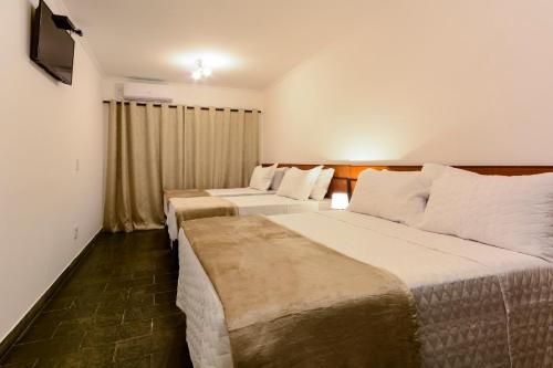 a hotel room with two beds and a television at Hotel Fazenda Aguas de Lindoia in Águas de Lindoia