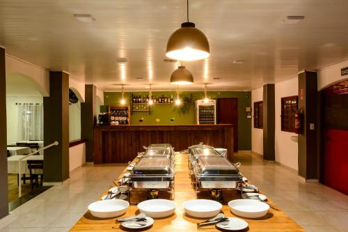 a long table with plates on it in a restaurant at Hotel Fazenda Aguas de Lindoia in Águas de Lindóia