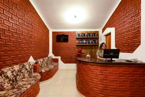 a woman sitting at a bar with a laptop at Hotel Fazenda Aguas de Lindoia in Águas de Lindóia