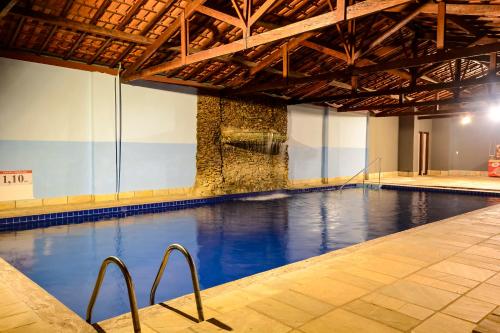 a swimming pool with blue water in a building at Hotel Fazenda Aguas de Lindoia in Águas de Lindóia