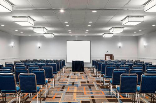 an empty room with chairs and a white screen at Four Points by Sheraton San Rafael Marin County in San Rafael