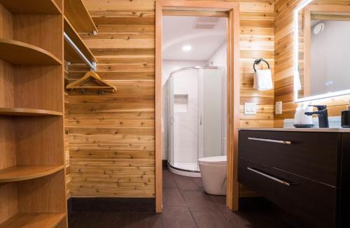 a bathroom with a toilet and wooden walls at Sunrise Valley Suite in West Kelowna
