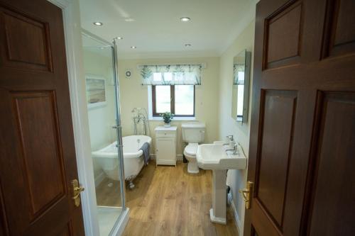 a bathroom with a tub and a toilet and a sink at The Stables in Woodhall Spa