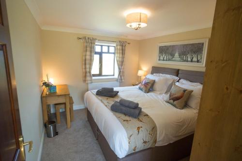 a bedroom with a large bed with two pillows on it at The Stables in Woodhall Spa