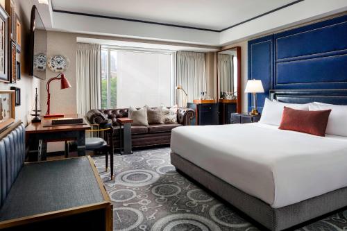 a bedroom with a large bed and a living room at The Liberty, a Luxury Collection Hotel, Boston in Boston