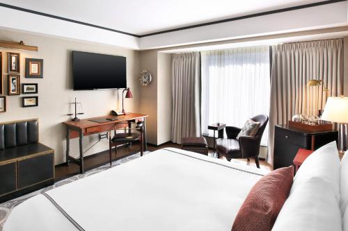 a hotel room with a bed and a desk at The Liberty, a Luxury Collection Hotel, Boston in Boston