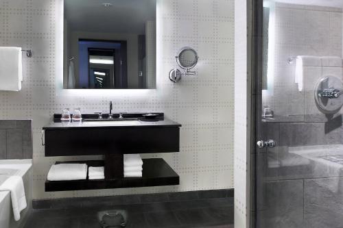 a bathroom with a sink and a mirror and a shower at The Liberty, a Luxury Collection Hotel, Boston in Boston