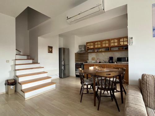 a kitchen and dining room with a table and a staircase at Penthouse Harriet Bansko in Bansko
