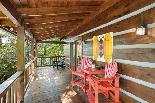 a porch with two red chairs and a table and a surfboard at The Mountain Peek in Blowing Rock