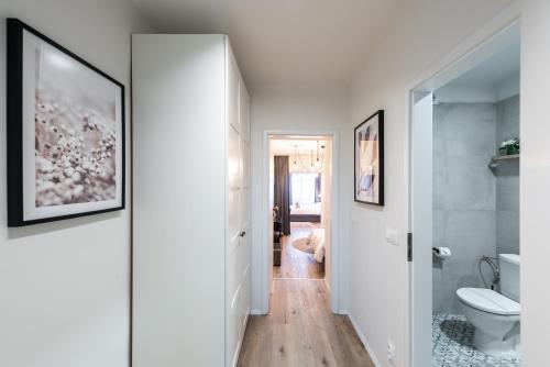 a white bathroom with a toilet and a hallway at Penzion Mácha in Litoměřice