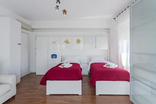 2 bedden in een witte kamer met rode lakens bij Casa Eleonora - Pavia - By HOST4U in Pavia