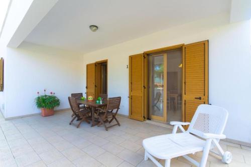Un patio con una mesa y sillas en una casa. en Blue Area Apartments - FromHomeToSalento, en Torre dell'Orso