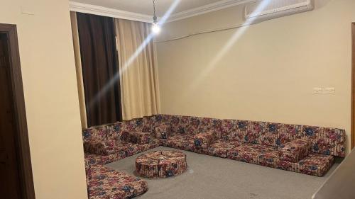 a living room with a couch and a table at شقة مميزه قرب البوابة الشمالية مفروشة بالكامل in Ţāb Kirā‘