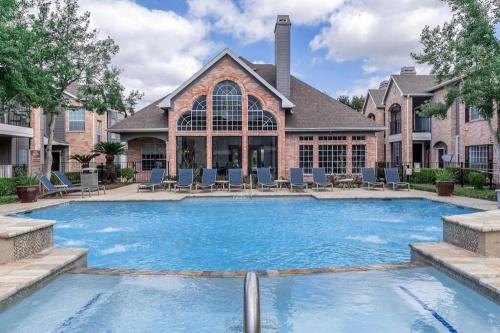 uma grande piscina em frente a uma casa em Vibrant 1BDR Attached Garage em Houston