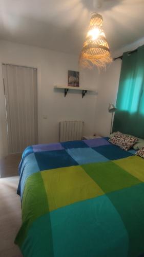 Dormitorio con cama de color arco iris con luz en Casa con encanto, en Corbera de Llobregat