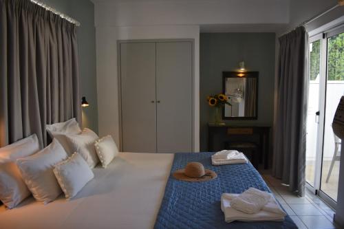 een hotelkamer met een bed met een hoed erop bij Mediterranea Apartments in Kato Daratso