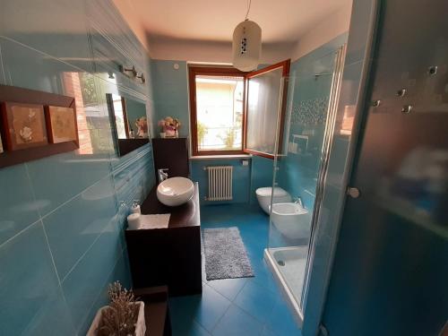 Baño azul con 2 aseos y ducha en Stanza nel verde a 14km da Torino, en La Loggia