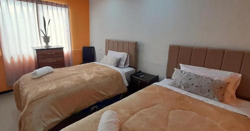 Un dormitorio con dos camas y una ventana. en Departamento en Plaza de Yanahuara, en Arequipa