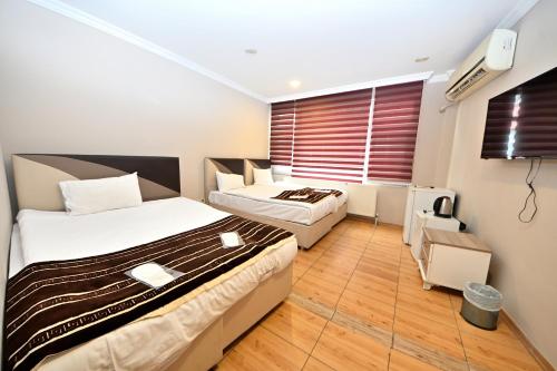 a hotel room with two beds and a window at Altınboynuz Family Hotel in Istanbul