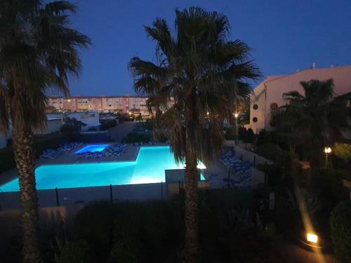 - une vue sur la piscine la nuit dans l'établissement ambassade des soleils, au Cap d'Agde