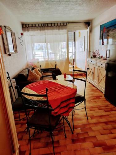 une pièce avec une table et des chaises et une cuisine dans l'établissement ambassade des soleils, au Cap d'Agde