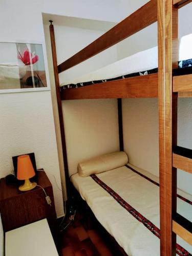 une chambre avec deux lits superposés et une lampe dans l'établissement ambassade des soleils, au Cap d'Agde