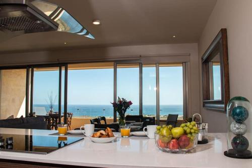 a kitchen with a table with fruit on it at Casa Bonita - Amazing new condo, best view in Cabo! in Cabo San Lucas