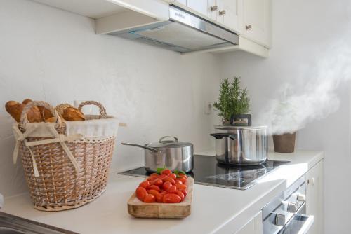 a kitchen counter with tomatoes and a basket of bread at Aeraki Villas in Santa Maria