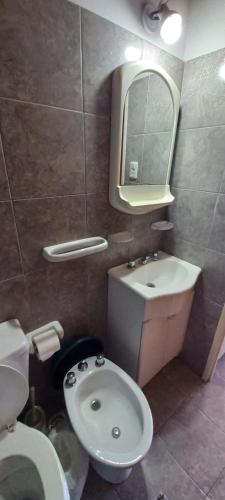 a bathroom with a sink and a toilet and a mirror at Cuty Nakey in Puerto Madryn