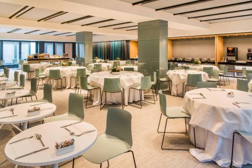 una sala da pranzo con tavoli e sedie bianchi di Four Points by Sheraton Venice Mestre a Mestre