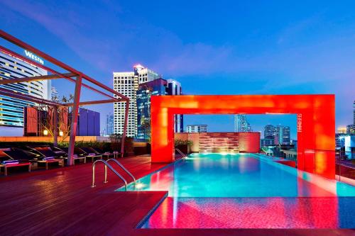 uma piscina no telhado de um edifício com um horizonte da cidade em Four Points by Sheraton Bangkok, Sukhumvit 15 em Banguecoque