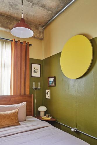 a bedroom with a bed and a yellow wall at DADA JAJA by DW in San Juan