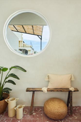 a mirror on a wall with a bench in a room at DADA JAJA by DW in San Juan