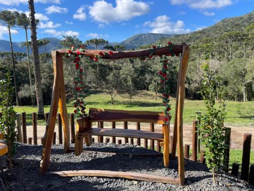 a wooden swing with flowers on it at Pousada Recanto da Neve in Urubici