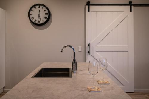 una cocina con dos copas de vino y un reloj en la pared en Friday's Rest, en Lake Tekapo
