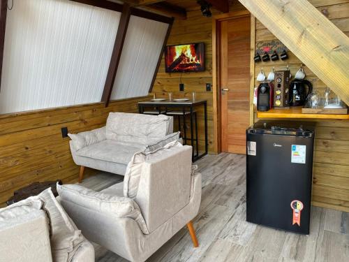 a living room with a couch and a chair and a table at Pousada Recanto da Neve in Urubici