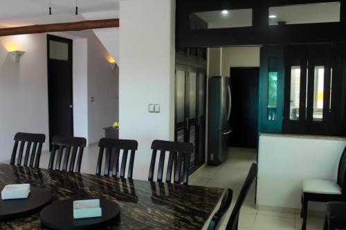 a dining room with a black table and chairs at Salamina Luxury private house in Uaymitun