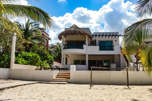 a white house on the beach with palm trees at Salamina Luxury private house in Uaymitun