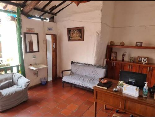 ein Wohnzimmer mit einem Sofa und einem Tisch in der Unterkunft Mi Ranchito, Centro in Barichara
