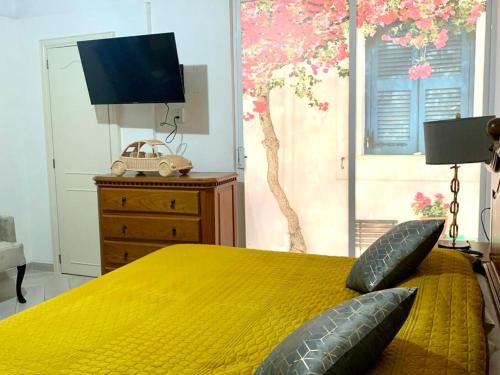 - une chambre avec un lit jaune et 2 oreillers dans l'établissement Bungamvilias Apartment, à Uruapan del Progreso