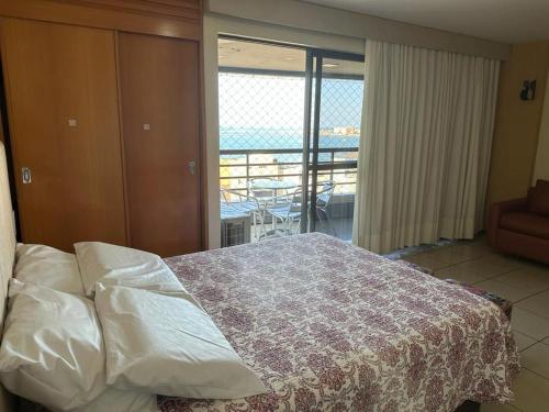 1 dormitorio con 1 cama y vistas a un balcón en Apartamento Em Andar Alto com Vista Mar Meireles, en Fortaleza