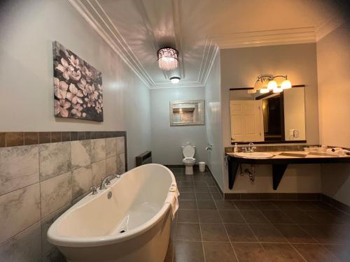 La salle de bains est pourvue d'une baignoire, d'un lavabo et de toilettes. dans l'établissement Wells Gray Inn, à Clearwater