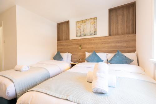 two beds in a hotel room with towels at The Chapter Hotels - Griffin House in London