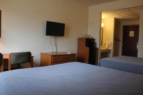 Habitación de hotel con 2 camas y TV de pantalla plana. en Heritage Inn and Suites, en Amory