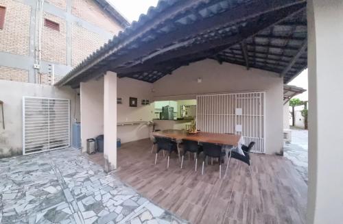 patio ze stołem i krzesłami w budynku w obiekcie Pé na Areia w mieście Itapipoca