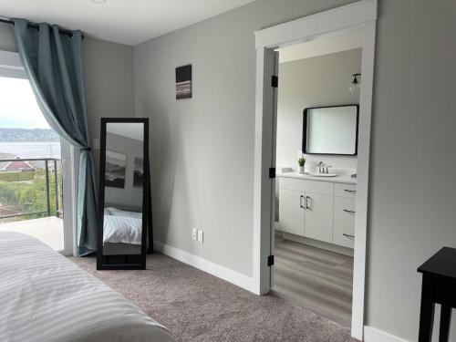 a bedroom with a mirror and a bathroom with a sink at Ocean View Oasis in Campbell River
