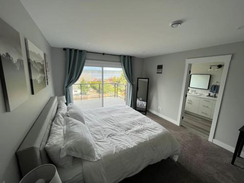 ein Schlafzimmer mit einem großen Bett und einem großen Fenster in der Unterkunft Ocean View Oasis in Campbell River
