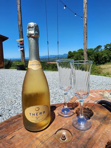 - une bouteille de vin et deux verres sur une table dans l'établissement Cabanas Românticas em meio a Natureza - Anitápolis/SC - CB05, à Annitapolis